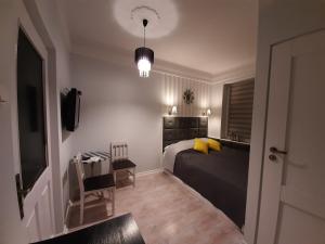 ブスコ・ズドロイにあるVilla Sensoのベッドルーム1室(黄色い枕とテーブル付きのベッド1台付)