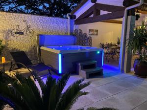 uma banheira de hidromassagem com luzes azuis num pátio em Mas Beau Soleil & Spa Gîtes de Charme avec Jacuzzi Privé em Saint-Rémy-de-Provence