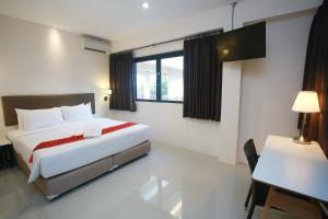 a bedroom with a bed and a table and a desk at Summer Tree Hotel in Bangna