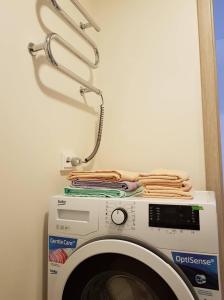 eine Waschmaschine mit einem Kleiderständer darüber in der Unterkunft Apartment for You in Klaipėda