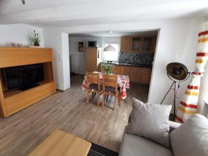 a living room with a table and a kitchen at Ferienwohnung Am Salzbach in Lemberg