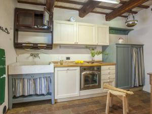 cocina con armarios blancos, fregadero y lavavajillas en Belvilla by OYO Camelle en Fermignano
