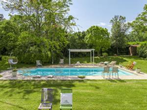 una piscina en un patio con sillas y cenador en Belvilla by OYO Camelle en Fermignano