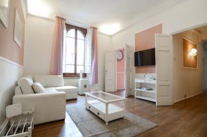 フィレンツェにあるSpeziali - Deluxe 2 bedroom flat nearby Piazza Repubblicaのリビングルーム(白いソファ、テーブル付)