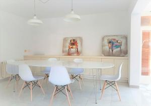 uma sala de jantar com uma mesa branca e cadeiras brancas em Finca Fila By LeMón Holiday em Esporles