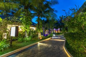 a walkway in a resort at night at Bali Hotel in Phnom Penh