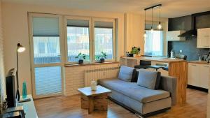 ein Wohnzimmer mit einem Sofa und einer Küche in der Unterkunft Studio Miła i Nido w Centrum APARTZAKOP in Zakopane
