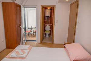 - une chambre avec un lit et une salle de bains avec des toilettes dans l'établissement Apartman Zenta, à Petrovac na Moru