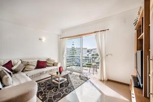 ein Wohnzimmer mit einem Sofa und einem großen Fenster in der Unterkunft Apartment Galé Garden 1A in Albufeira