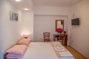 a bedroom with a bed and a table with a mirror at Apartman Zenta in Petrovac na Moru