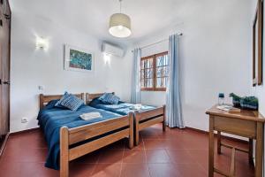 a bedroom with a blue bed in a room at Íris by Algarve Villa Holidays in Galé +10 photos