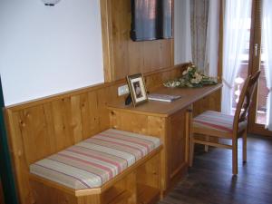 Zimmer mit einem Schreibtisch mit einer Bank und einem Stuhl in der Unterkunft Alpenhotel Pfaffenwinkel in Peiting