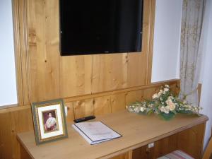 uma mesa com uma foto e uma foto de um homem em Alpenhotel Pfaffenwinkel em Peiting