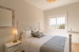 a white bedroom with a bed and a window at La Llevantina Boutique Villa in Calonge +61 photos