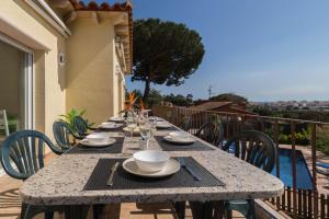 a stone table with plates and bowls on a balcony at La Llevantina Boutique Villa in Calonge