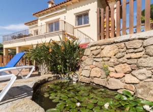 a stone wall with a pond in front of a house at La Llevantina Boutique Villa in Calonge