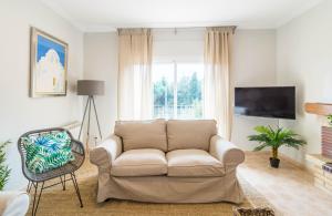 a living room with a couch and a tv at La Llevantina Boutique Villa in Calonge