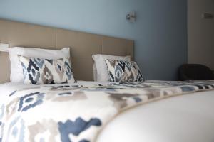 a bed with a white comforter and pillows at Hotel Ancora Mar in Nazaré