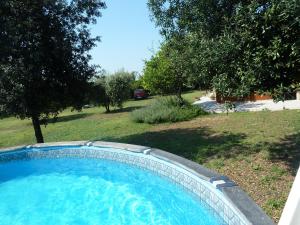 uma piscina azul num quintal com árvores em 'O Chalet em Pozzuoli