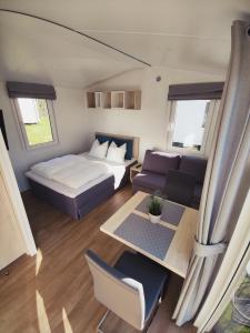 City Camping Hjørring في يورينغ: غرفة نوم بسرير واريكة وطاولة