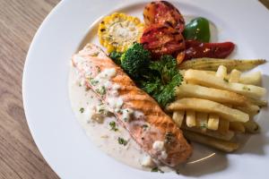 a white plate of food with fish and french fries at S Ratchada Leisure Hotel in Bangkok