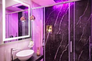 a purple bathroom with a sink and a shower at La Lepre Napoli in Naples