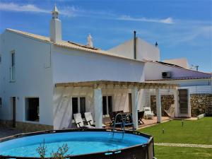 a villa with a swimming pool in front of a house at Casa do Tonel in Sagres