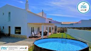 a villa with a swimming pool in front of a house at Casa do Tonel in Sagres