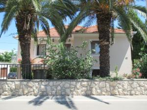 dom z palmami przed nim w obiekcie CANDY ap.-near center,bus,beach+free parking place w mieście Zadar