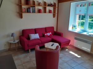 a living room with a red couch and a table at Gite du gros pommier in Saulxures