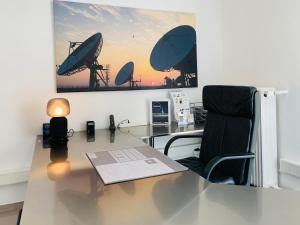 ein Büro mit einem Schreibtisch mit einem Stuhl und einem Bild an der Wand in der Unterkunft apartment11 in Ulm