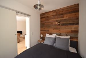 Schlafzimmer mit einer Wand mit Holzakzenten und einem Bett in der Unterkunft Harztraum in Bad Harzburg