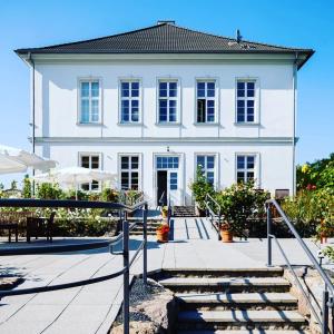 duży biały dom ze schodami przed nim w obiekcie Gutshaus Groß Helle w mieście Mölln