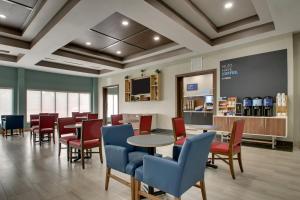 a waiting room with tables and chairs and a counter at Holiday Inn Express & Suites Laurel, an IHG Hotel in Laurel