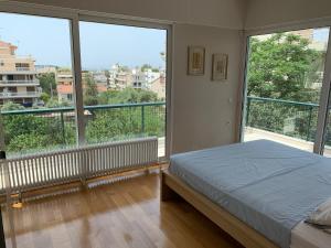 1 dormitorio con cama y ventana grande en OASIS Exclusive Apartment @ Athenian Riviera, en Atenas