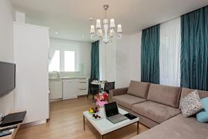 a living room with a couch and a table with a laptop at The Room Hotel & Apartments in Antalya