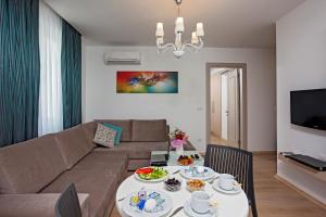 a living room with a couch and a table with food on it at The Room Hotel & Apartments in Antalya