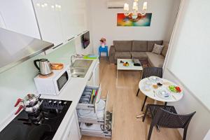 a small kitchen and a living room with a table at The Room Hotel & Apartments in Antalya