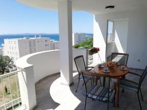 a table and chairs on a balcony with a view of the ocean at Sea view Apartment Reno w/garage in Split