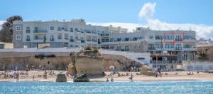 a group of people on a beach with buildings at Fábrica da Ribeira 53 by Destination Algarve in Lagos