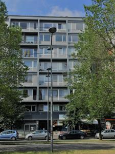 Un grand bâtiment avec des voitures garées devant lui dans l'établissement DayNight Sauveniere, à Liège