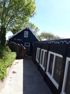 een zwart huis met een hek ernaast bij strandhuis De Bakkeete A in Kamperland