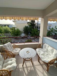 a balcony with chairs and a table on a balcony at Stella Maisonette Hanioti in Hanioti