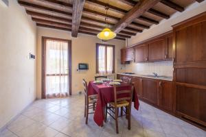 eine Küche mit einem Tisch und einem roten Tischtuch in der Unterkunft Il Castelluccio - by Bolgheri Holiday in Monteverdi Marittimo
