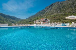 une grande piscine avec des chaises et un hôtel dans l'établissement Lavender Bay Apartment F7, à Donji Morinj