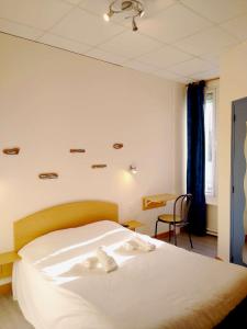 - une chambre avec un lit et des serviettes blanches dans l'établissement Hôtel des Sables Blancs, à Douarnenez