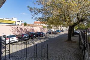 ein Parkplatz mit Autos neben einem Baum in der Unterkunft V12 Apartments - Vittoria 12 in Novara