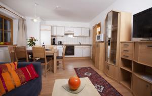 a kitchen and living room with a couch and a table at Appartementhaus Erasim in Schladming +5 photos