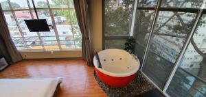 eine Badewanne in einem Zimmer mit einem großen Fenster in der Unterkunft Bonita Boutique Hotel in Ho-Chi-Minh-Stadt