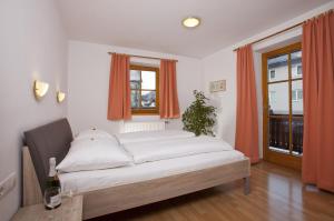 Cama grande en habitación con ventana en Appartementhaus Erasim, en Schladming